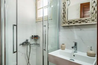 a bathroom with a shower and a sink and a mirror at Alianthos Villa in Tersanas