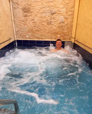 a man in a jacuzzi in a hot tub at Stone Mansion in Káïna