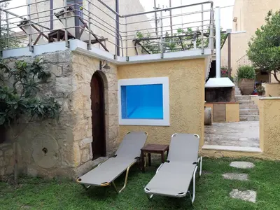 a patio with two chairs and a table and a screen at Stone Mansion in Káïna