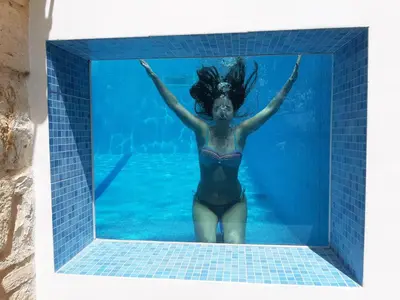 a woman in a swimming pool at Stone Mansion in Káïna