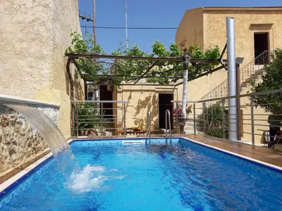 a swimming pool with a water fountain at Stone Mansion in Káïna