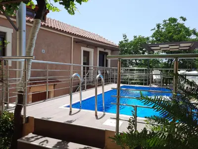 a swimming pool in front of a house at Stone Mansion in Káïna