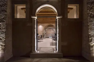 an archway in a building with tables and chairs at Monastery Estate Venetian Harbor in Chania Town