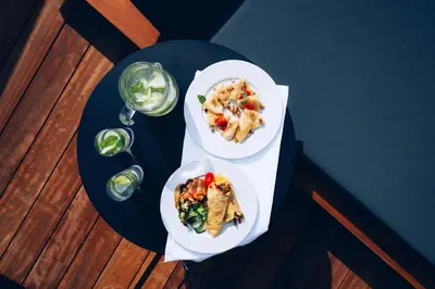 two plates of food on a table with glasses of wine at Monastery Estate Venetian Harbor in Chania Town