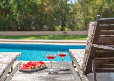 a table with two glasses of wine and a plate of fruit at Nikola's Villa Stalos Chania in Stalos
