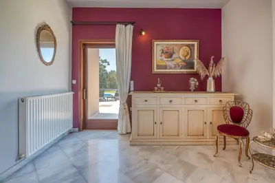 a living room with a wooden cabinet and a door at Nikola's Villa Stalos Chania in Stalos