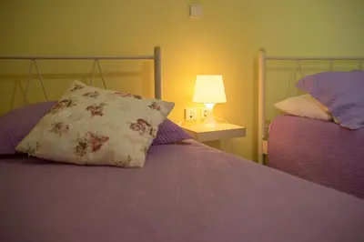 a bedroom with two beds with a pillow and a lamp at Nikola's Villa Stalos Chania in Stalos
