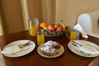 a table with two plates of food and a basket of fruit at Mini Art Apartments in Gerani Chanion
