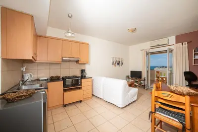 a kitchen and living room with a couch and a table at Mini Art Apartments in Gerani Chanion