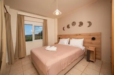 a bedroom with a large bed and a window at Mini Art Apartments in Gerani Chanion