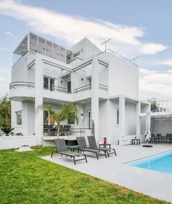 a white house with a swimming pool and lawn at Villa Giota in Chania Town