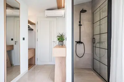 a bathroom with a walk in shower and a glass door at Villa Giota in Chania Town