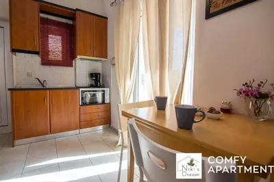 a kitchen with a wooden table and a counter top at Nikis Dream Comfy Apartments in Chania Town