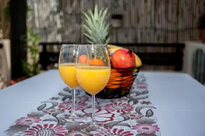 two glasses of orange juice and a basket of fruit at Kyriaki's Cozy Apartments in Agia Marina Nea Kydonias