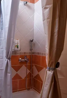 a shower with a shower curtain in a bathroom at Kyriaki's Cozy Apartments in Agia Marina Nea Kydonias