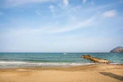 a beach with a group of rocks in the water at Athina Apartments Near The Sea Platania in Plataniás