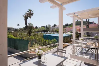 a balcony with tables and a view of a pool at Athina Apartments Near The Sea Platania in Plataniás