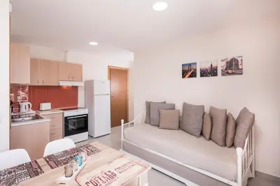 a living room with a couch and a kitchen at Athina Apartments Near The Sea Platania in Plataniás