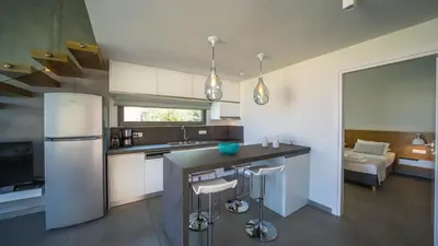 a kitchen with a refrigerator and a counter with stools at Iskios Villas in Agia Marina Nea Kydonias