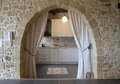 a kitchen with an archway in a stone wall at Villa Meli-milon in Kolymvari