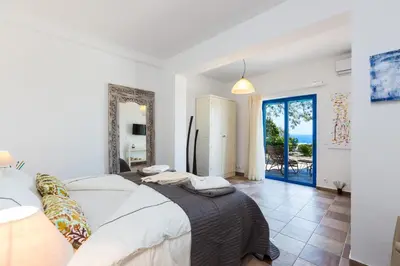 a bedroom with a bed and a view of the ocean at Villa Blanca Collection in Kalathas