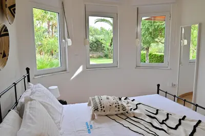 a white bedroom with windows and a bed at Elia Seaside Villa, Amazing 2-Story Eco Pool House! in Kissamos