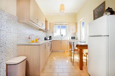 a kitchen with a white refrigerator and a table at Irini Apartment II in Kalyves