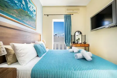 a bedroom with a large bed with a television on the wall at Irini Apartment II in Kalyves