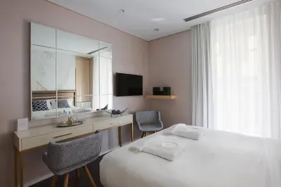a bedroom with a bed and a desk and a mirror at Consolato Boutique in Chania Town
