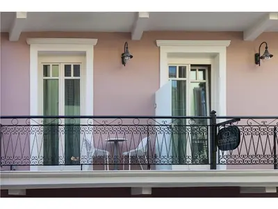 a balcony with a black railing and two windows at Consolato Boutique in Chania Town