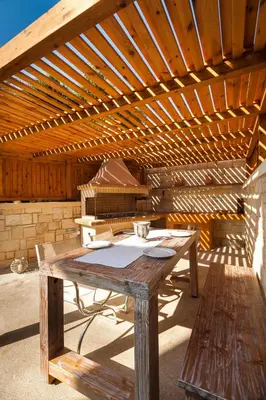 a wooden table sitting under a wooden roof at Villa Stellina in Marathokefála