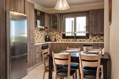 a kitchen with a table with chairs and a refrigerator at Villa Stellina in Marathokefála