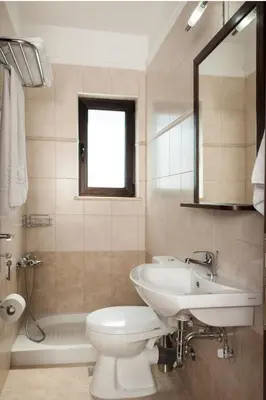a bathroom with a sink and a toilet and a mirror at Villa Stellina in Marathokefála