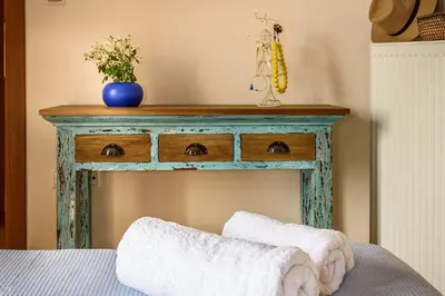 an old console table with a blue vase on top at Platanias Sky View in Plataniás