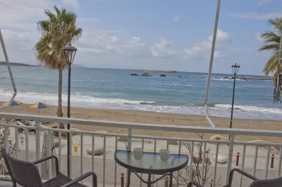 a table and chairs on a balcony overlooking the beach at Danaos Hotel in Chania Town