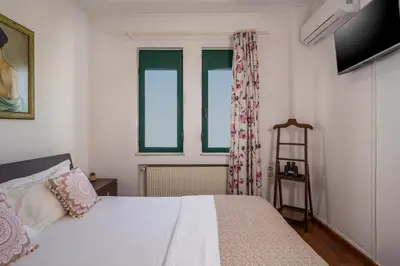 a bedroom with a bed and two windows at Vaggelio House in Chania Town