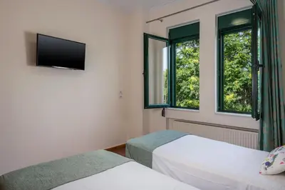 two beds in a room with two windows at Vaggelio House in Chania Town