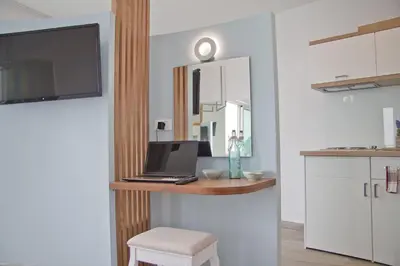 a kitchen with a desk with a laptop and a stool at Christina Beach Hotel in Chania Town