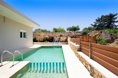 a swimming pool in the backyard of a house at Vrahokipos Villa in Kounoupidhianá