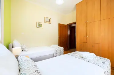 a bedroom with two beds and a wooden cabinet at Vrahokipos Villa in Kounoupidhianá