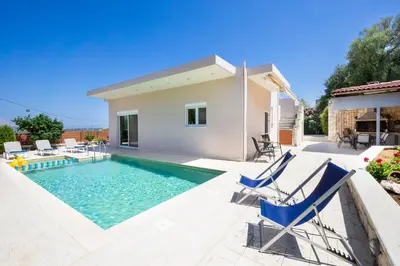 a villa with a swimming pool and a house at Vrahokipos Villa in Kounoupidhianá
