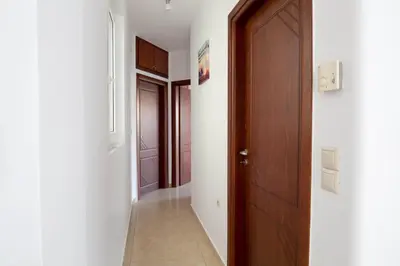 a hallway with a wooden door and a hallwayngth at Chania Sea View Apartment with Free Private Parking in Chania Town
