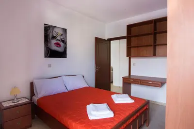 a bedroom with a bed with a black and white face on the wall at Chania Sea View Apartment with Free Private Parking in Chania Town