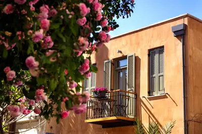 a building with a balcony with pink flowers on it at La Casa Piccola in Chania Town