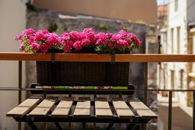 a planter with pink flowers on a balcony at La Casa Piccola in Chania Town