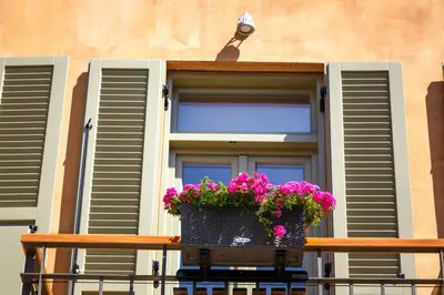 a window with a pot of flowers on a balcony at La Casa Piccola in Chania Town