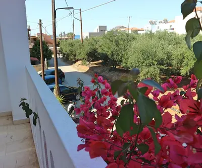 a bunch of red flowers on a white fence at Oliaria Apartments in Plataniás