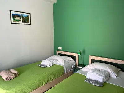 two beds in a room with green walls at Villa Nopigia Somina in Kissamos