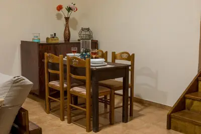 a dining room table with chairs and a vase with flowers at Lithari in Kámboi