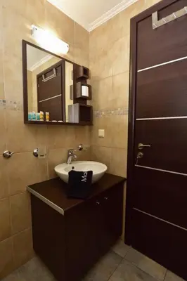 a bathroom with a sink and a mirror at Gonis Suites in Palaiochóra